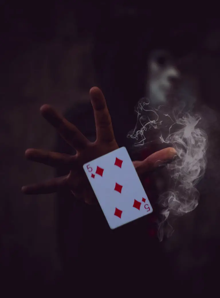 person holding 5 of Diamonds playing card
